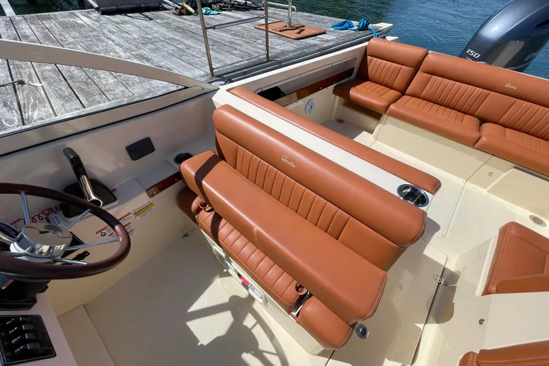 Slide: The Image of 2022 Rossiter 20 boat interior with brown leather seating and steering wheel. - 33