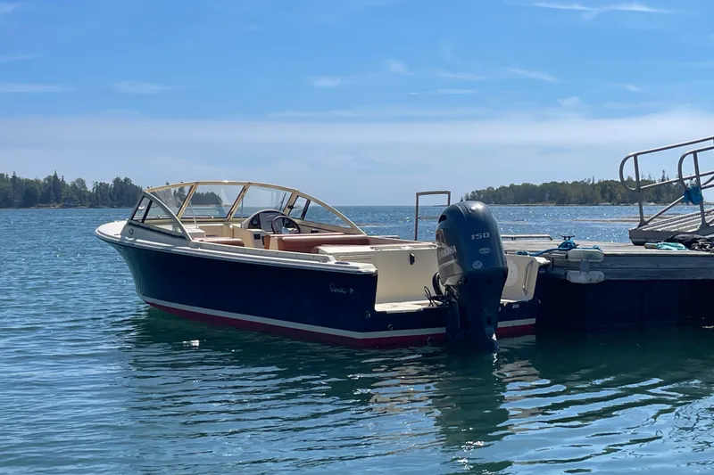 The Image of 2022 Rossiter 20 boat docked on a serene lake under a clear blue sky. - 0
