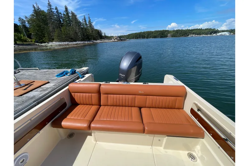 Slide: The Image of 2022 Rossiter 20 boat with tan seating, docked by a scenic lake. - 30