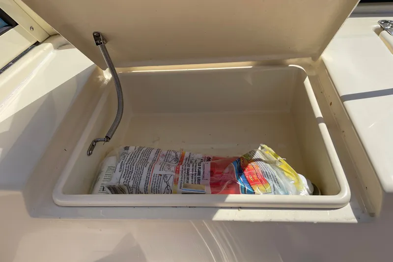 Slide: The Image of Open storage compartment on 2022 Rossiter 20 boat with packaged items inside. - 41