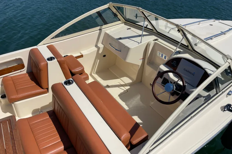 Slide: The Image of 2022 Rossiter 20 boat interior with brown leather seats and Garmin navigation system. - 25