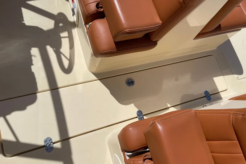 Slide: The Image of 2022 Rossiter 20 boat interior with tan leather seats and storage compartment. - 38