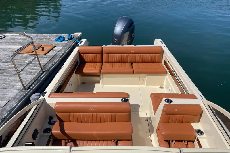 Slide: The Image of 2022 Rossiter 20 boat with tan leather seating, docked by a wooden pier. - 57