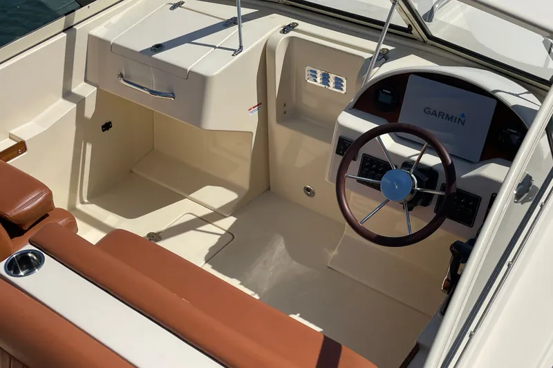 Slide: The Image of 2022 Rossiter 20 boat interior with Garmin navigation, brown leather seating, and sleek steering wheel. - 26