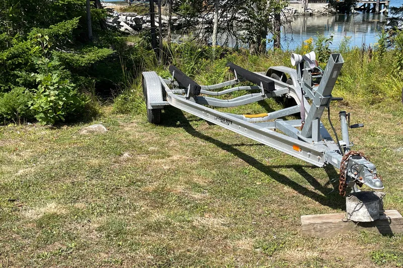 Slide: The Image of Trailer for 2022 Rossiter 20 boat on grassy area near water. - 58