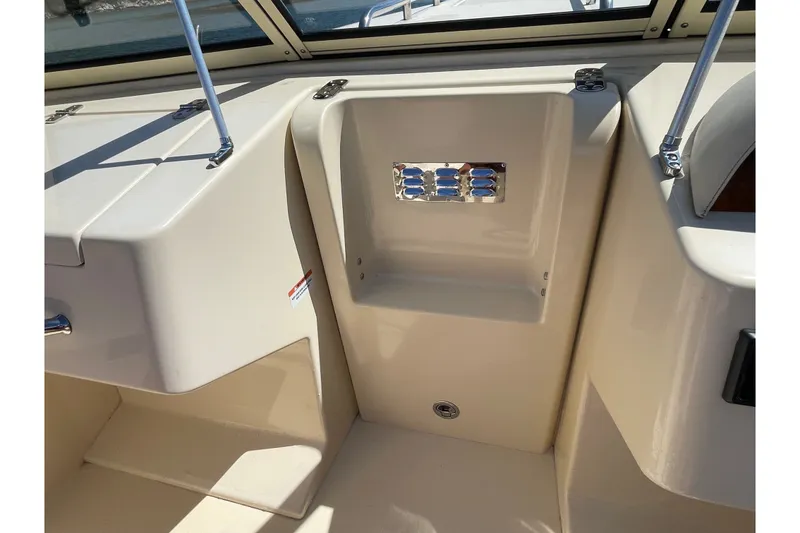 Slide: The Image of 2022 Rossiter 20 boat interior detail with beige seating and chrome accents. - 49