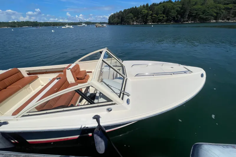 Slide: The Image of 2022 Rossiter 20 boat on serene lake with lush green shoreline. - 54