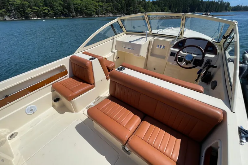 Slide: The Image of 2022 Rossiter 20 boat interior with tan leather seats, steering wheel, and scenic water view. - 31