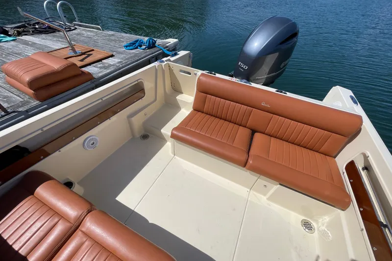 Slide: The Image of 2022 Rossiter 20 boat with tan leather seats and outboard motor by the dock. - 28