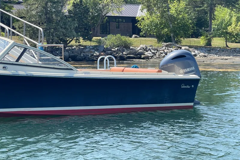 Slide: The Image of 2022 Rossiter 20 boat with Yamaha engine on calm water near rocky shore. - 14