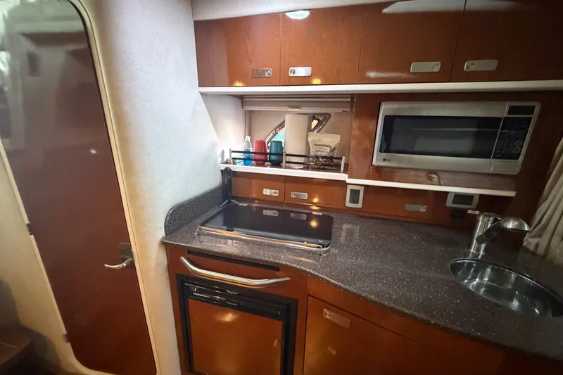 Slide: The Image of 2012 Sea Ray Sundancer 330 yacht kitchen with microwave, stove, and sink. - 28