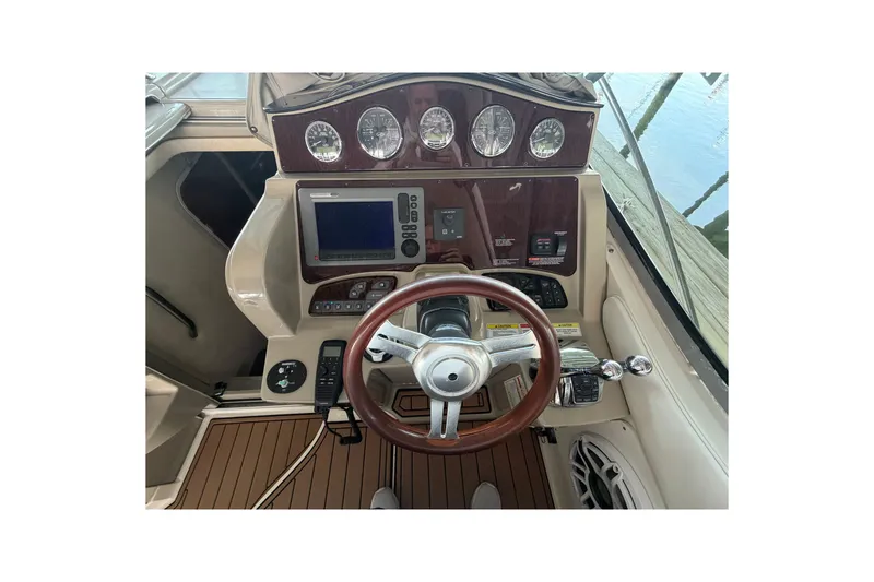 Slide: The Image of Cockpit view of 2012 Sea Ray Sundancer 330 with steering wheel and navigation controls. - 30