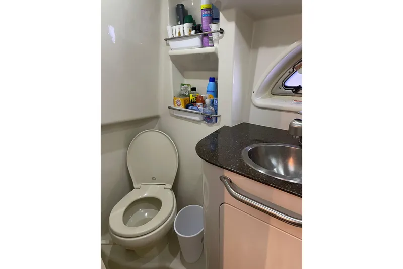 Slide: The Image of 2012 Sea Ray 330 Sundancer bathroom with toilet, sink, and storage shelves. - 20