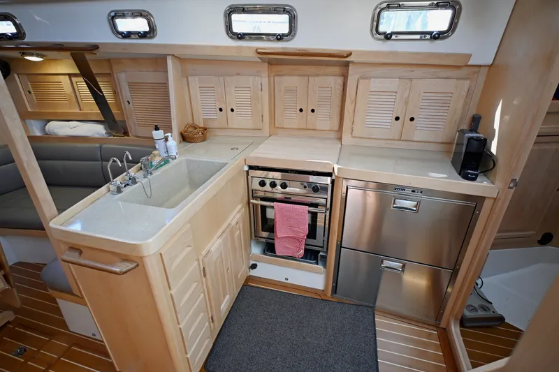 Slide: The Image of Modern kitchen interior of 2024 Tartan 395 yacht with wooden cabinetry and stainless steel appliances. - 10
