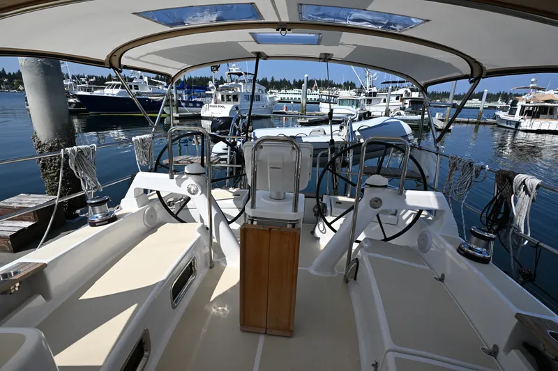 Slide: The Image of 2024 Tartan 395 yacht cockpit with dual steering wheels, docked at a marina. - 43