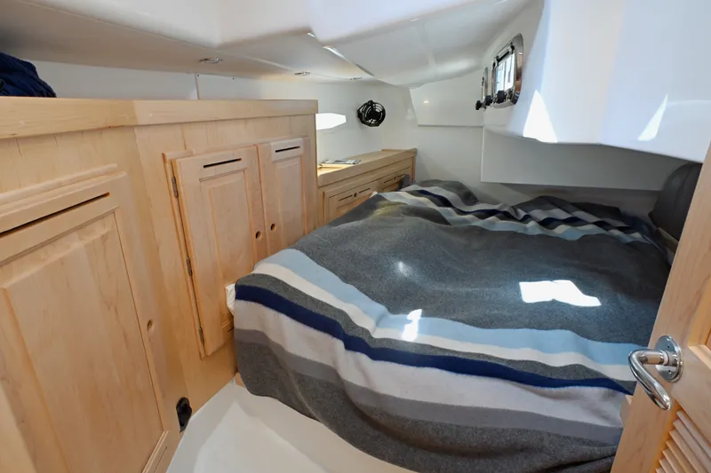 Slide: The Image of Cozy cabin interior of 2024 Tartan 395 yacht with striped bedding and wooden cabinetry. - 14