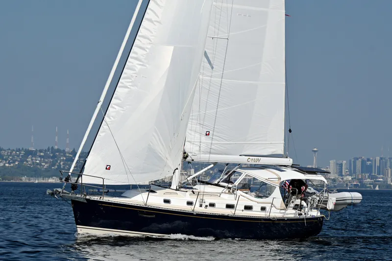 Slide: The Image of Sailing yacht Tartan 395, 2024 model, cruising on open water with city skyline backdrop. - 62