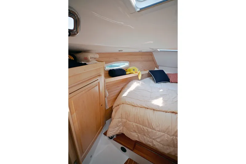 Slide: The Image of Cozy cabin interior of 2024 Tartan 395 yacht with wooden paneling and plush bedding. - 6