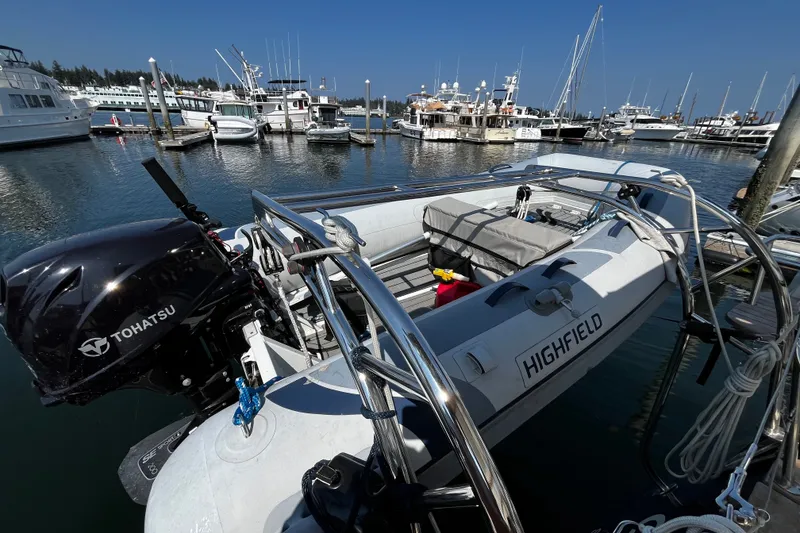 Slide: The Image of 2024 Tartan 395 boat docked with Tohatsu motor, surrounded by marina and other vessels. - 46