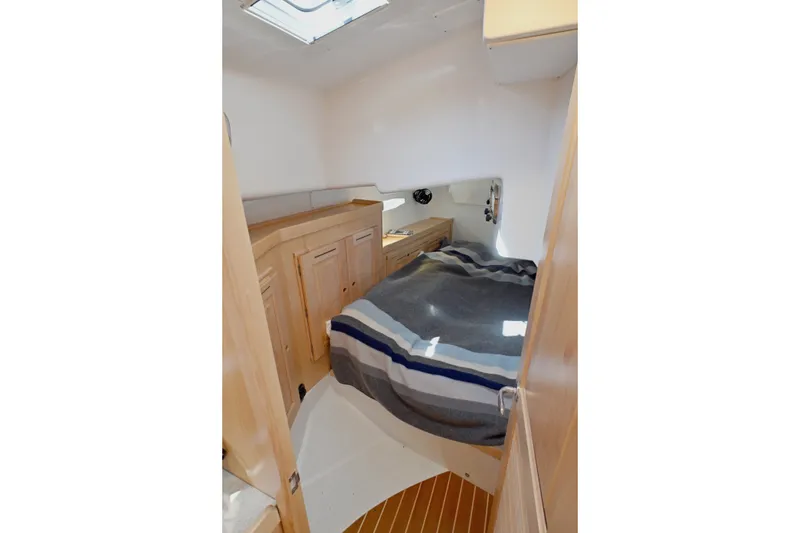 Slide: The Image of 2024 Tartan 395 yacht interior cabin with cozy bed and wooden cabinetry. - 11