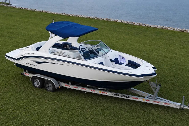 Slide: The Image of 2013 Chaparral 287 SSX boat on trailer, parked on grass near water. - 5