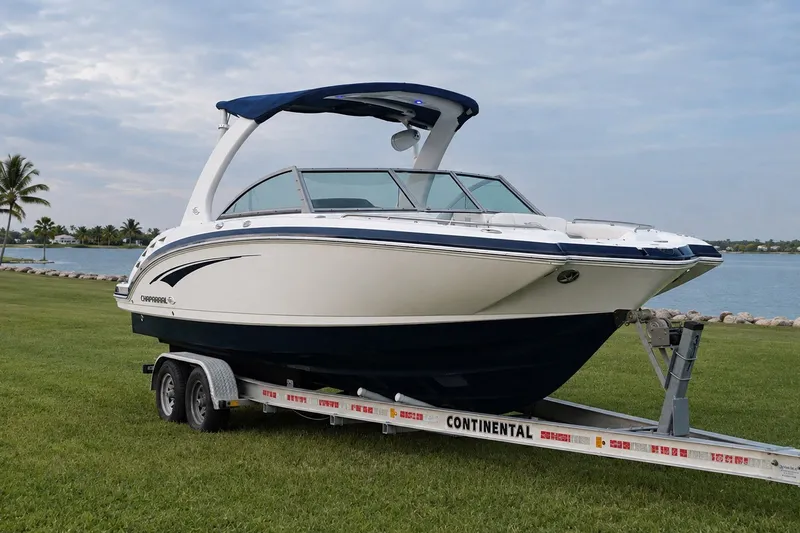Slide: The Image of 2013 Chaparral 287 SSX boat on trailer by waterfront, under cloudy sky. - 10