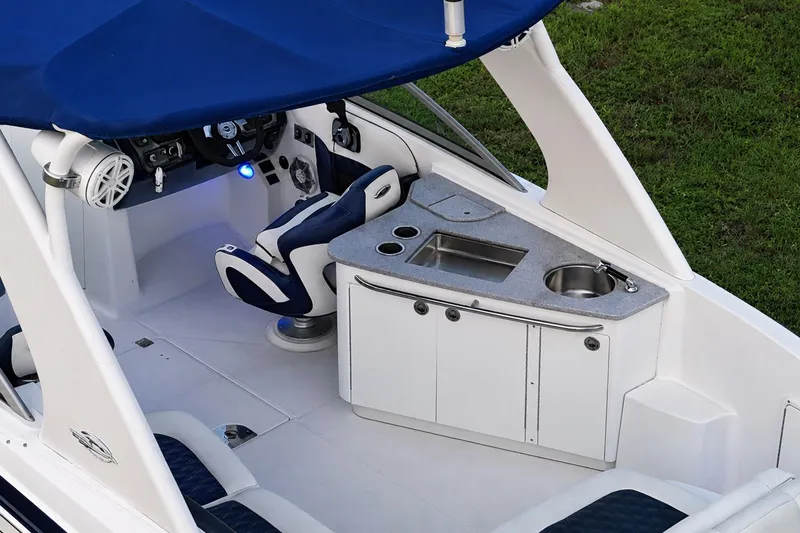 Slide: The Image of 2013 Chaparral 287 SSX boat interior with helm, seating, and kitchenette. - 28
