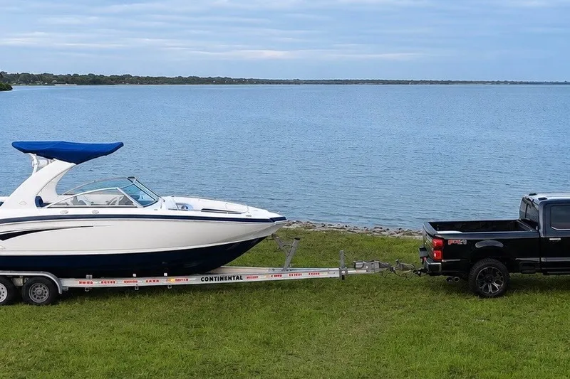 Slide: The Image of 2013 Chaparral 287 SSX boat on trailer by lake, towed by black truck. - 13