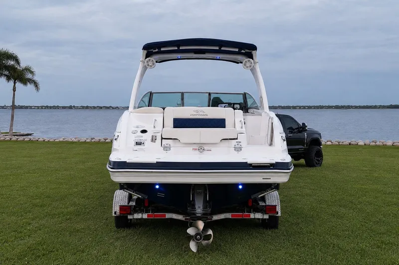 Slide: The Image of 2013 Chaparral 287 SSX boat on trailer by a lakeside, with a truck nearby. - 4