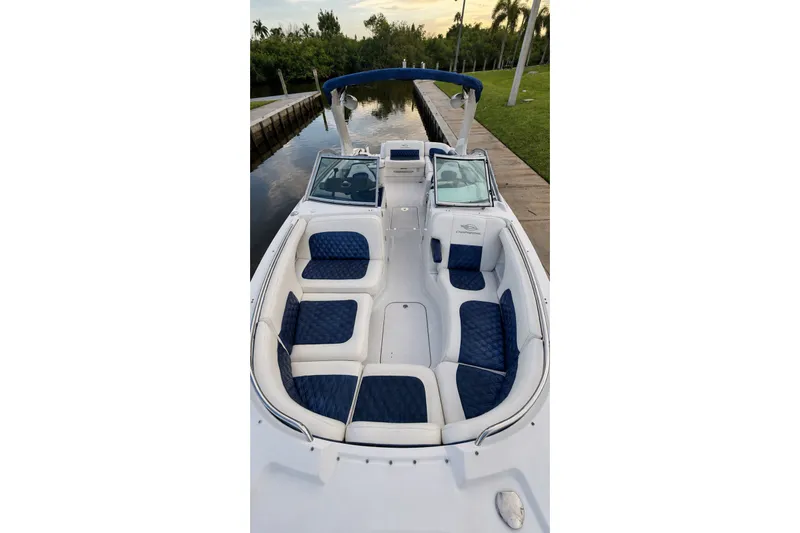 Slide: The Image of 2013 Chaparral 287 SSX boat with blue and white seating, docked by a canal. - 17