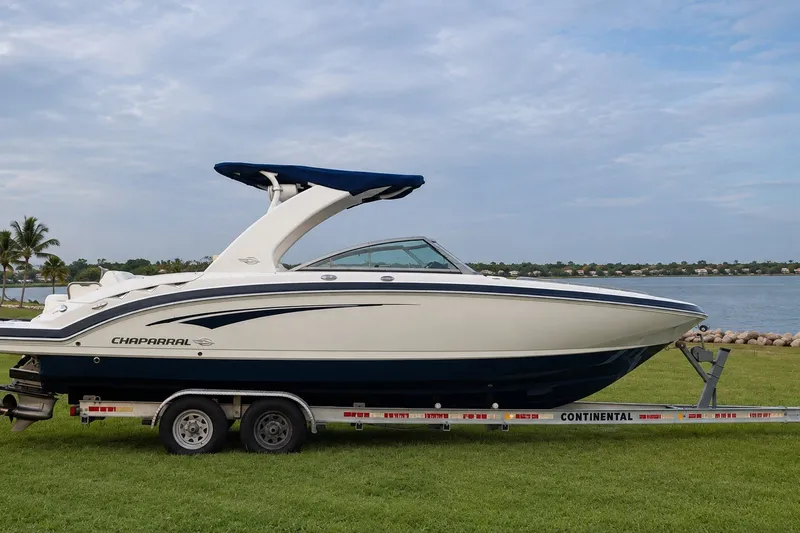 Slide: The Image of 2013 Chaparral 287 SSX boat on trailer by a lakeside, under a cloudy sky. - 8