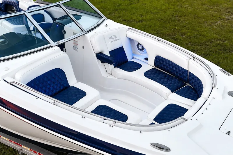 Slide: The Image of 2013 Chaparral 287 SSX boat with luxurious blue and white seating, docked on grass. - 18
