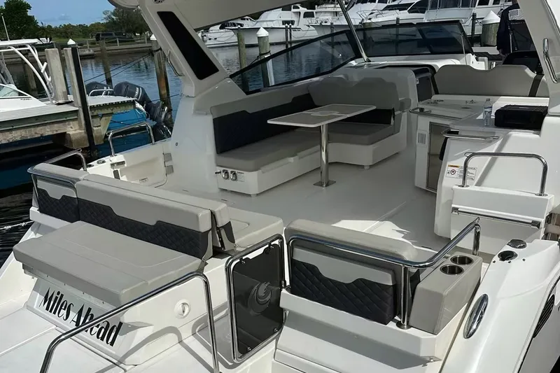 Slide: The Image of 2023 Aquila 36 Sport yacht interior with seating and table, docked at marina. - 19