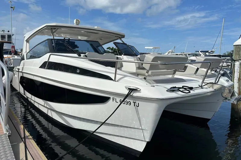 Slide: The Image of 2023 Aquila 36 Sport boat docked at marina under clear blue sky. - 4