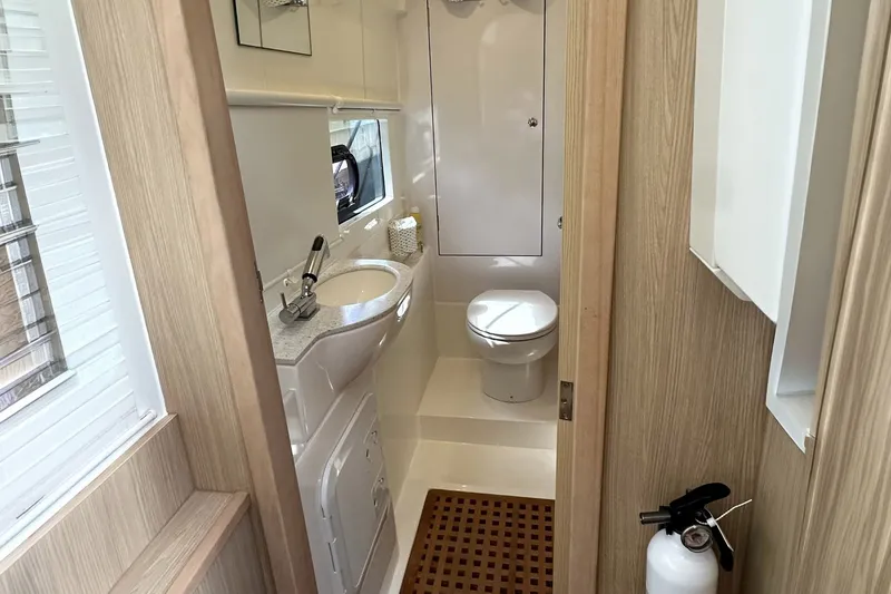 Slide: The Image of Modern bathroom interior on 2023 Aquila 36 Sport yacht, featuring sink, toilet, and fire extinguisher. - 23