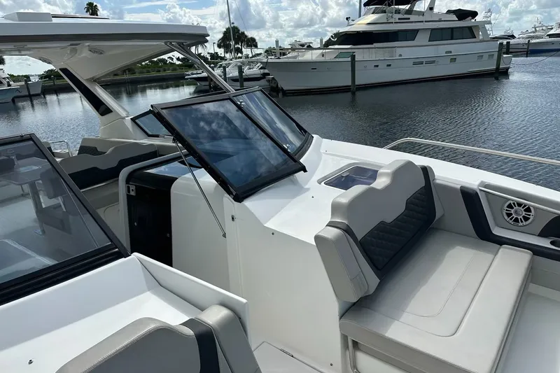 Slide: The Image of 2023 Aquila 36 Sport boat interior with seating and dashboard, docked at marina. - 8
