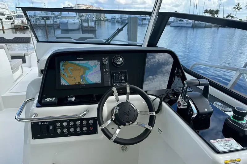 Slide: The Image of Helm of 2023 Aquila 36 Sport boat with navigation display and controls. - 10