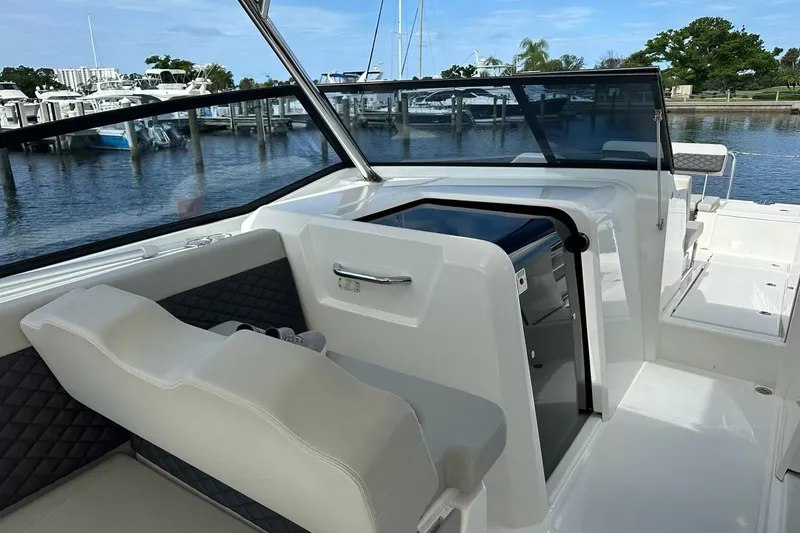 Slide: The Image of 2023 Aquila 36 Sport boat interior with seating and open cabin door at marina. - 9