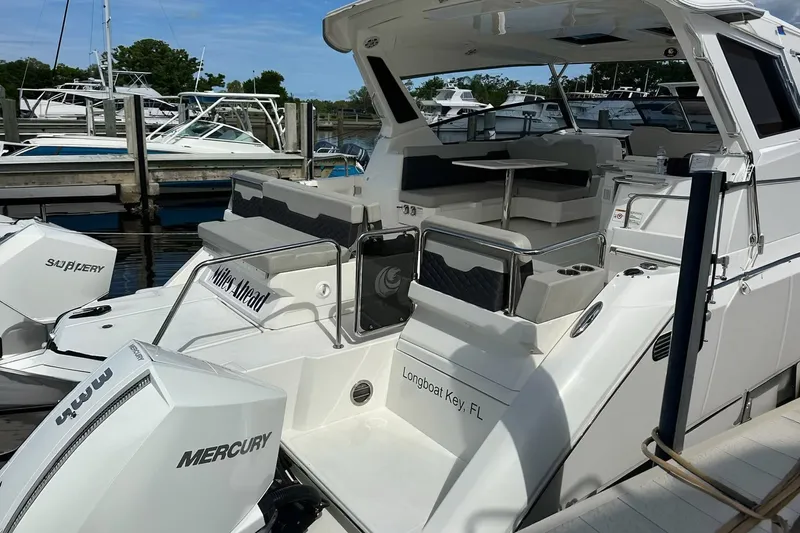 Slide: The Image of 2023 Aquila 36 Sport boat docked, featuring spacious seating and Mercury engines. - 20
