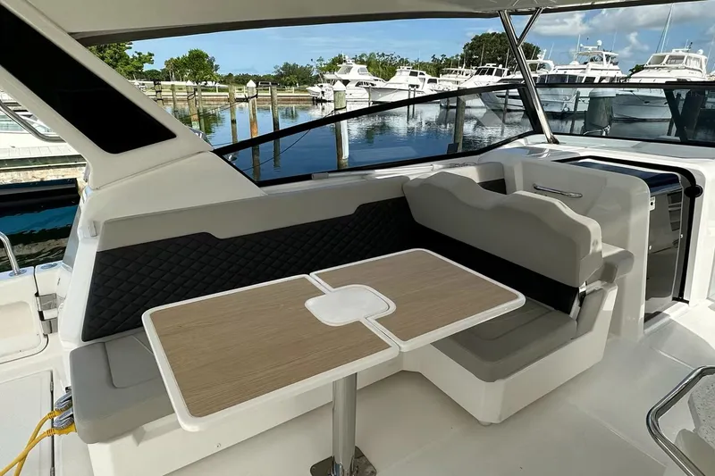 Slide: The Image of 2023 Aquila 36 Sport yacht interior with seating and table, docked at marina. - 14