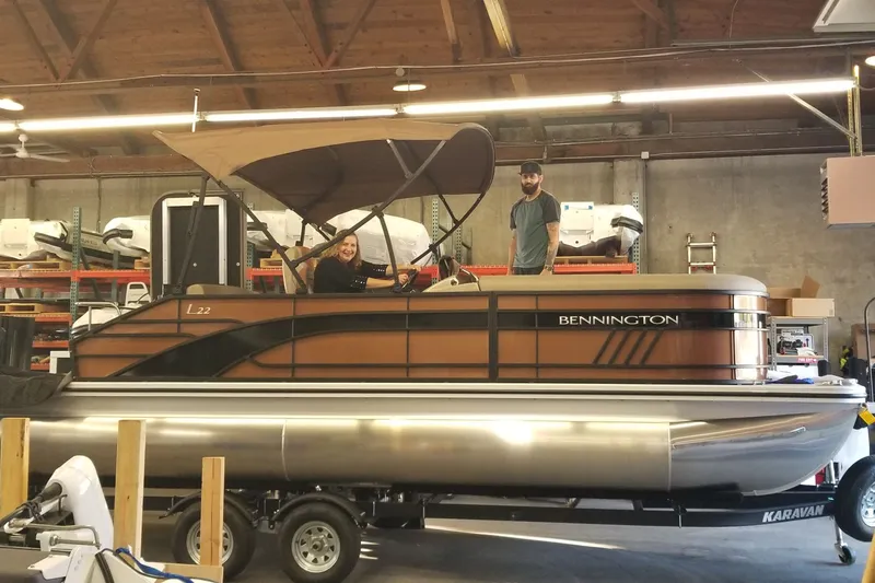 The Image of 2023 Bennington 22 LSB pontoon boat in a showroom with two people onboard. - 1