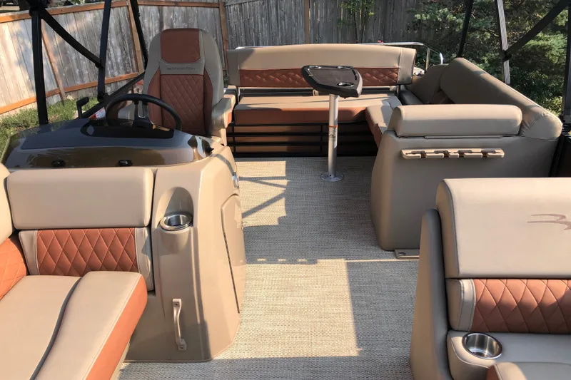 Slide: The Image of 2023 Bennington 22 LSB pontoon boat interior with tan and brown seating. - 15
