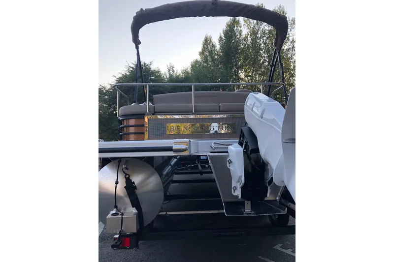 Slide: The Image of 2023 Bennington 22 LSB pontoon boat with canopy, rear view, parked outdoors. - 8
