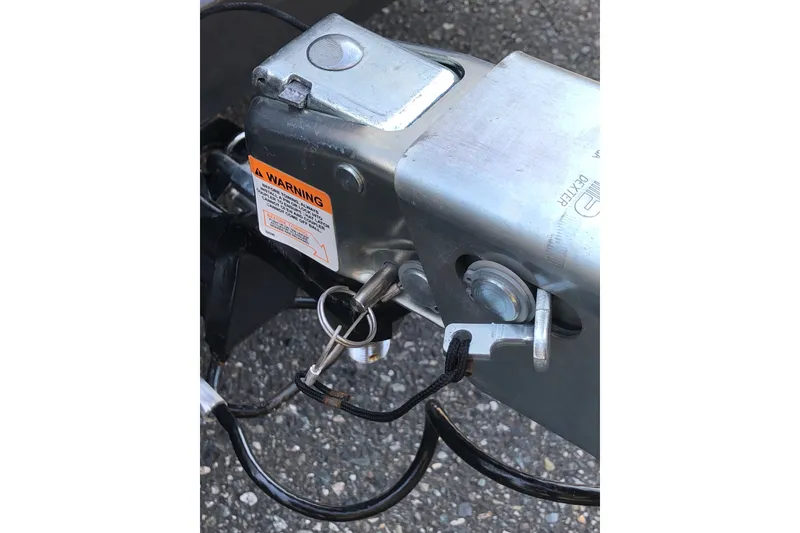 Slide: The Image of Close-up of a 2023 Bennington 22 LSB trailer hitch with safety pin and warning label. - 13