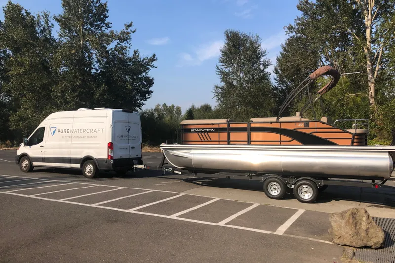 Slide: The Image of 2023 Bennington 22 LSB pontoon boat on trailer, towed by Pure Watercraft van. - 4