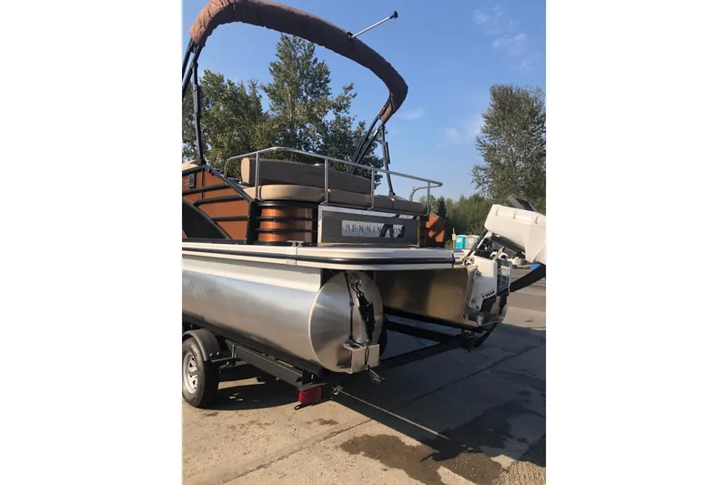Slide: The Image of 2023 Bennington 22 LSB pontoon boat on trailer, parked outdoors. - 3