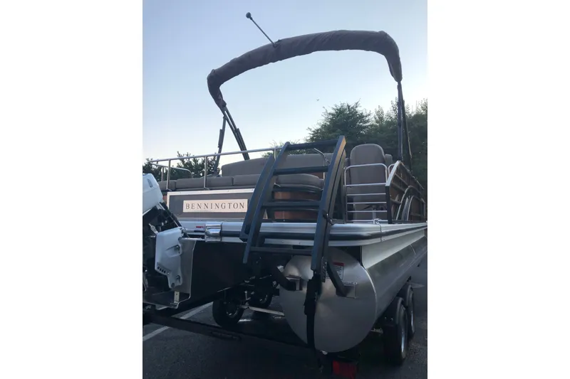 Slide: The Image of 2023 Bennington 22 LSB pontoon boat with canopy, parked on a trailer. - 12