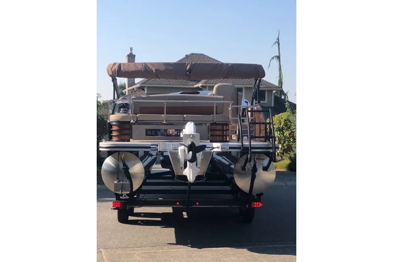 Slide: The Image of 2023 Bennington 22 LSB pontoon boat with canopy, parked in driveway. - 17