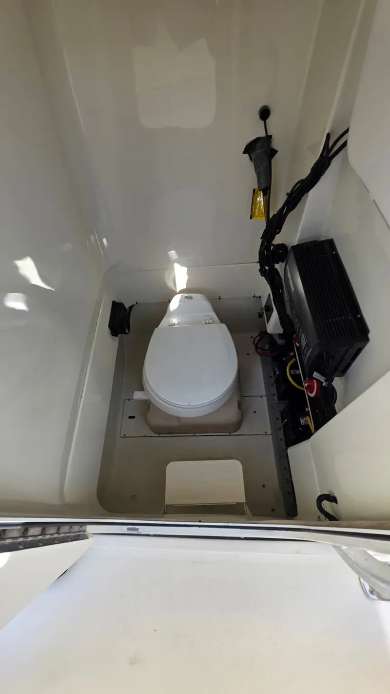 Slide: The Image of The image shows a compact boat toilet with a white seat and electrical connections. - 10