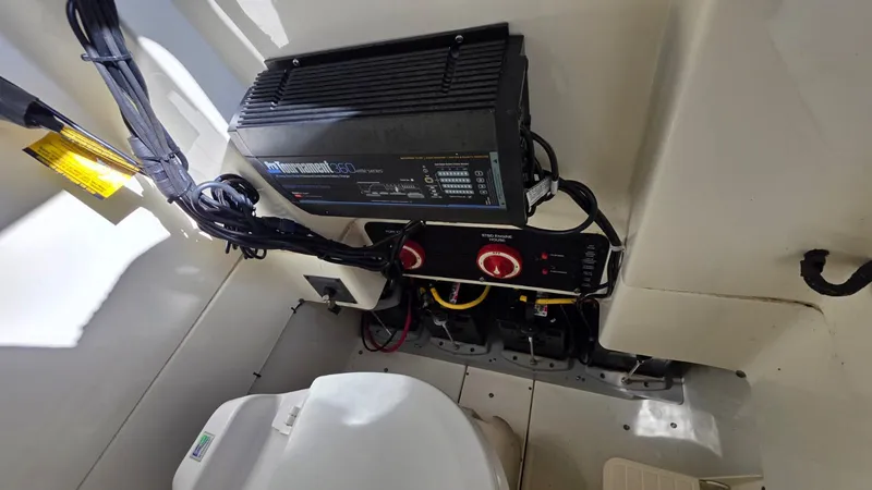 Slide: The Image of An electrical system with a battery charger and switches inside a boat. - 12